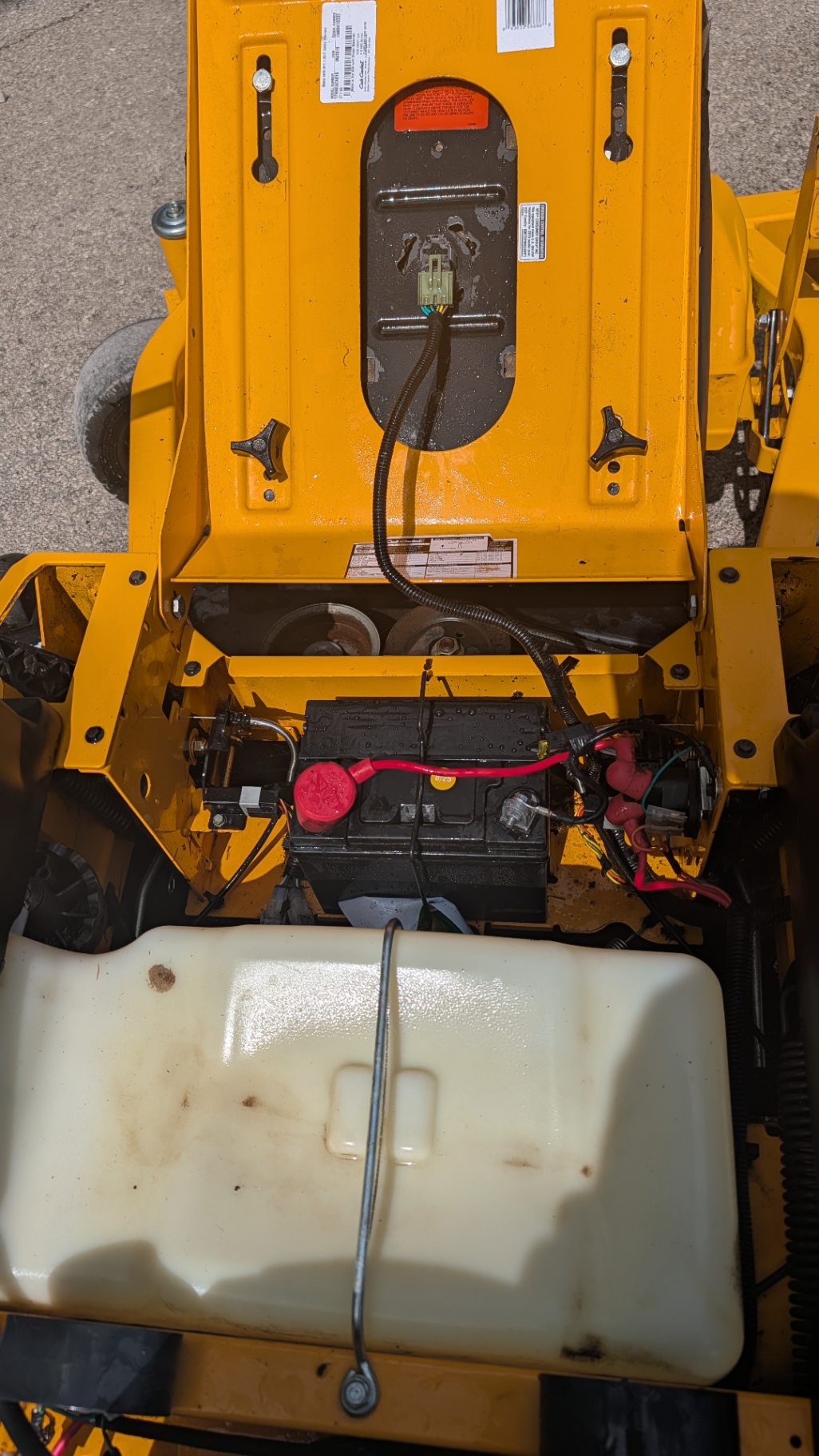 Battery and wiring under the seat of a Cub Cadet zero-turn mower