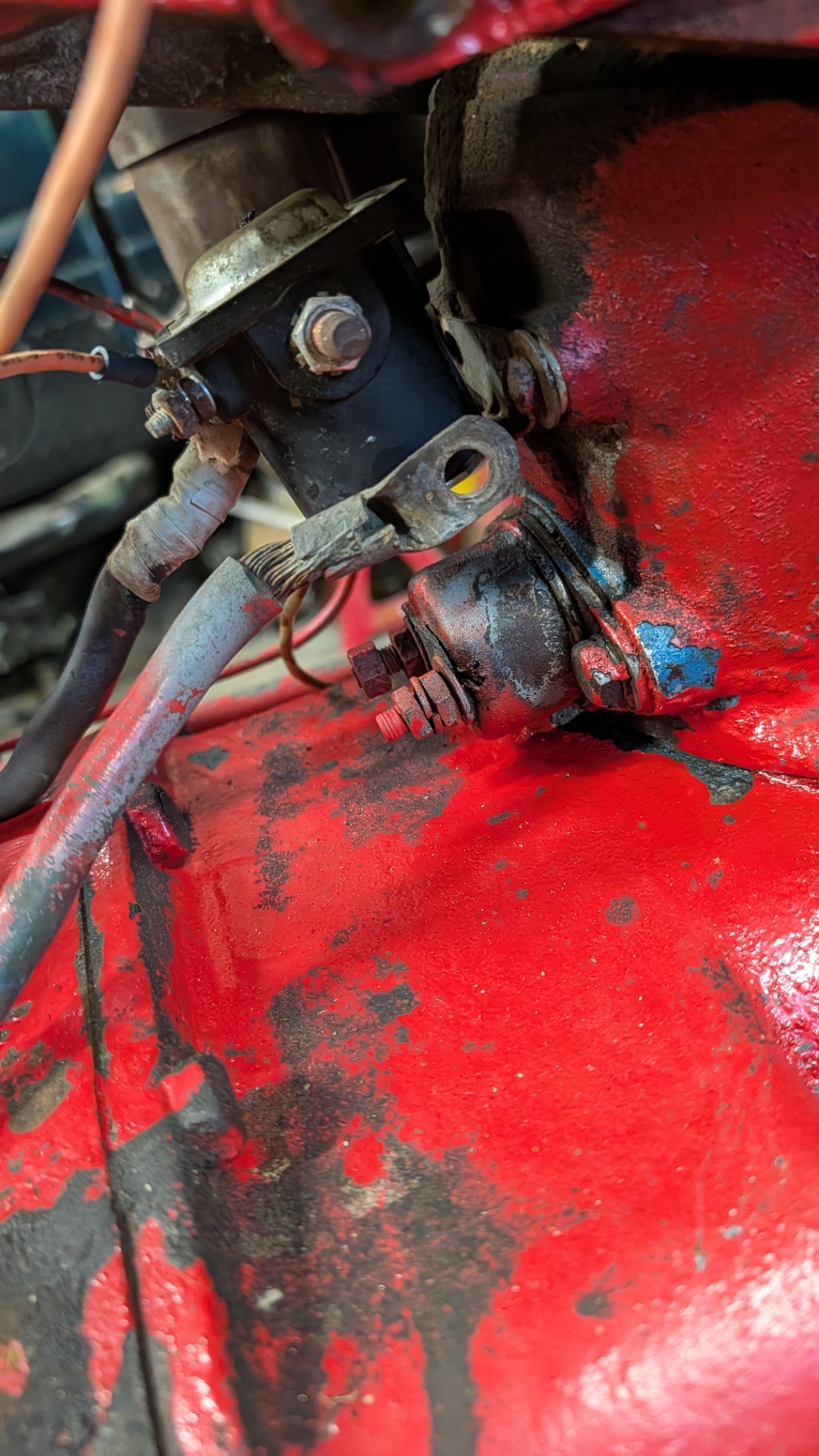 Tractor starter and solenoid mounted on a red engine block