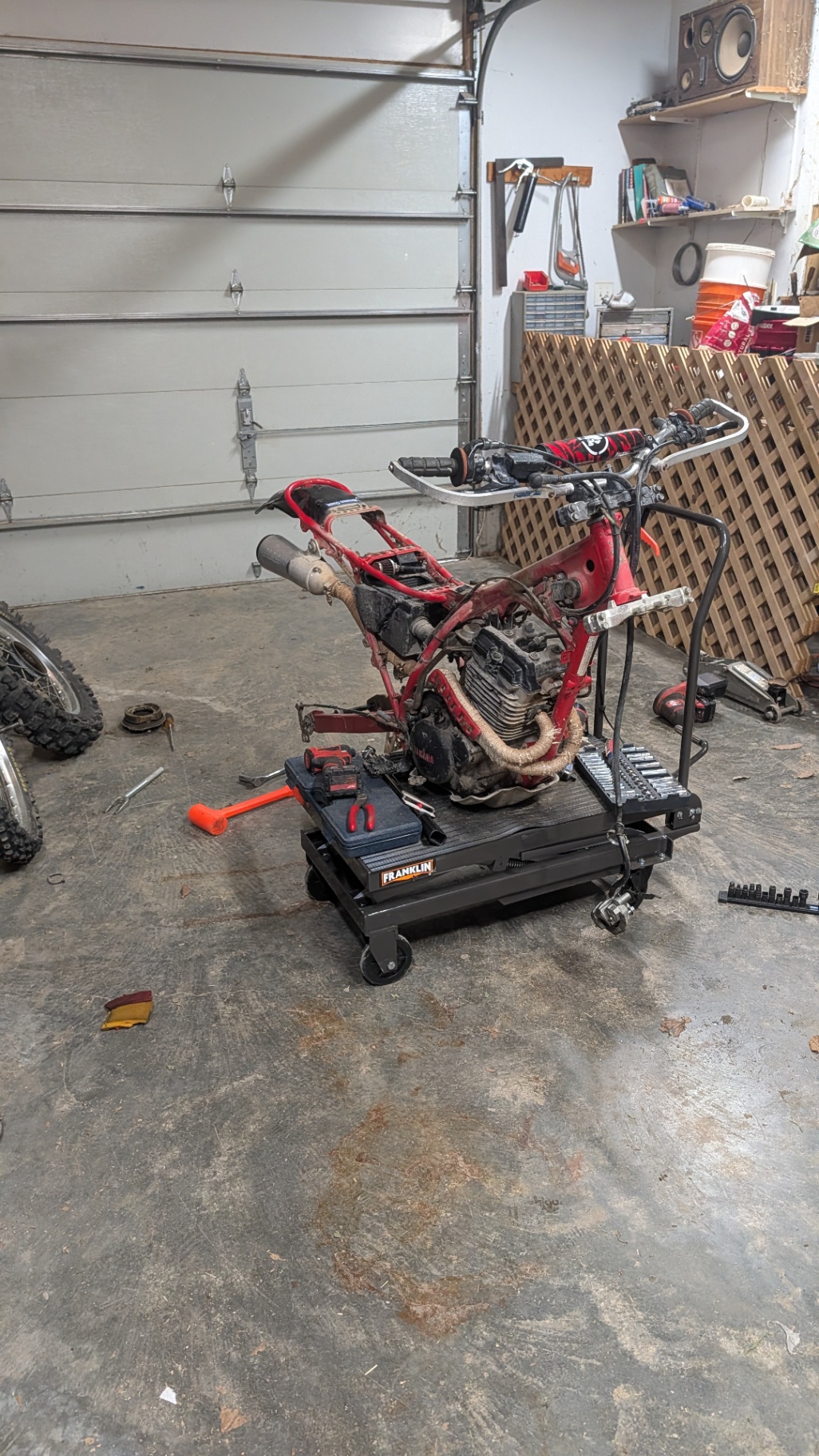 Yamaha 350 dirt bike stripped to the frame on a lift in the shop