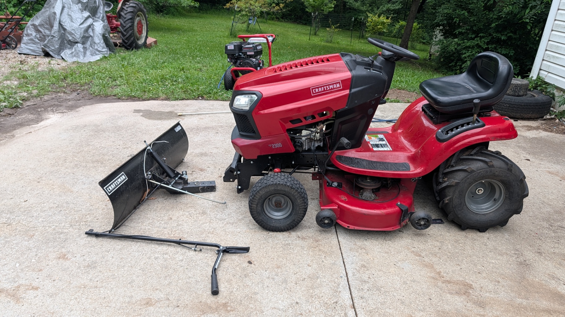 Craftsman T2300 riding mower with a plow blade attachment